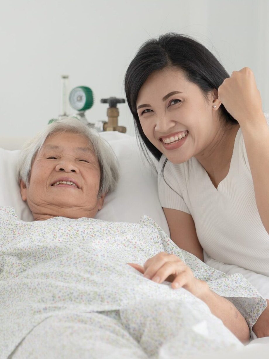close up of patient grandfather and women holding hands in hospital bed